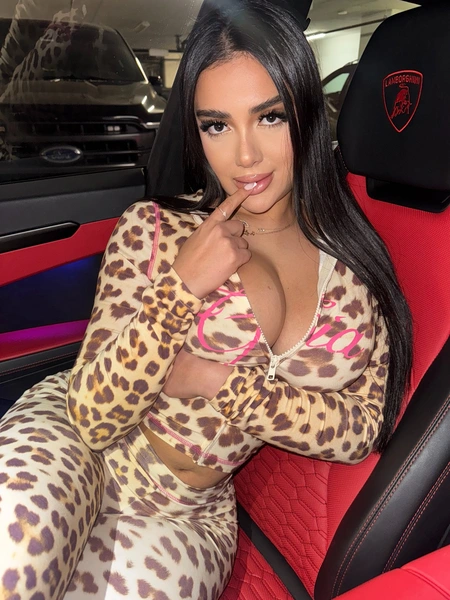 Mary Yousefi (@itsmimipeach) in a leopard print set sitting in a red Lamborghini interior