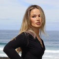 Close-up portrait of Australian creator Isabelle Clarke looking away against a soft ocean waves background
