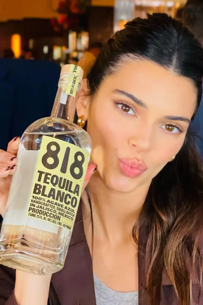 Kendall Jenner posing with a bottle of her tequila brand 818