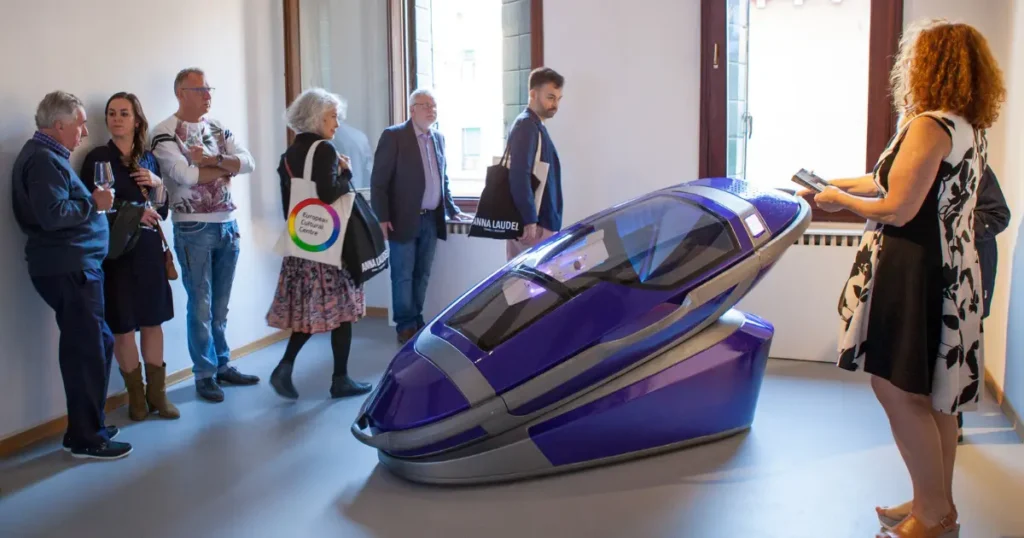 People viewing a Sarco assisted-suicide capsule on display at an event